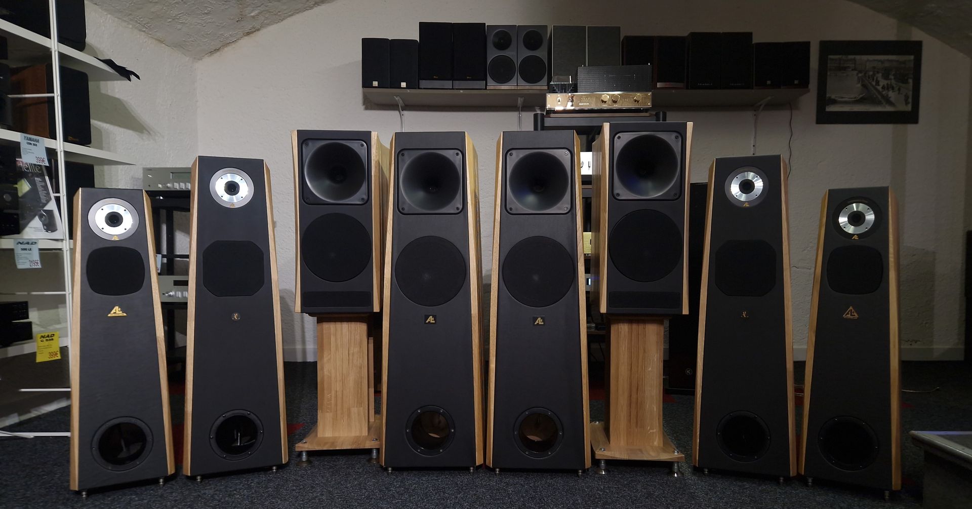 Enceintes colonnes alignées devant un mur blanc