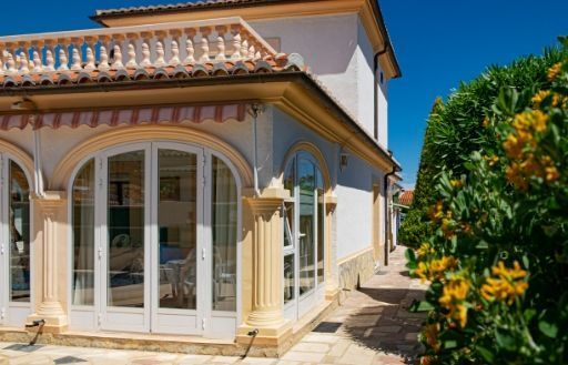Una casa grande con muchas ventanas y balcón.