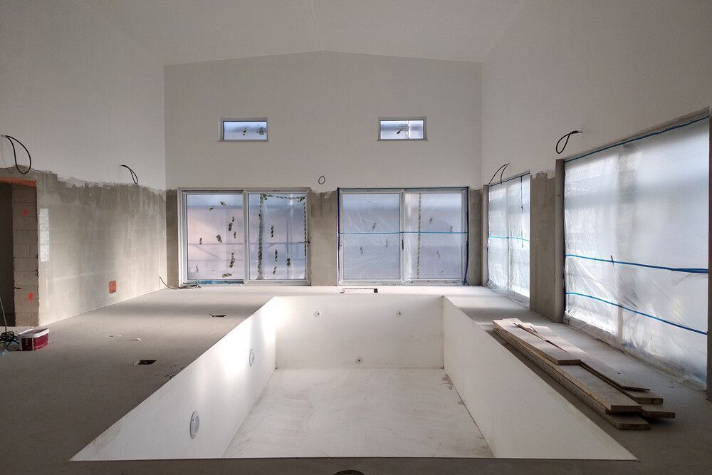 Una habitación vacía con una gran piscina en el medio.