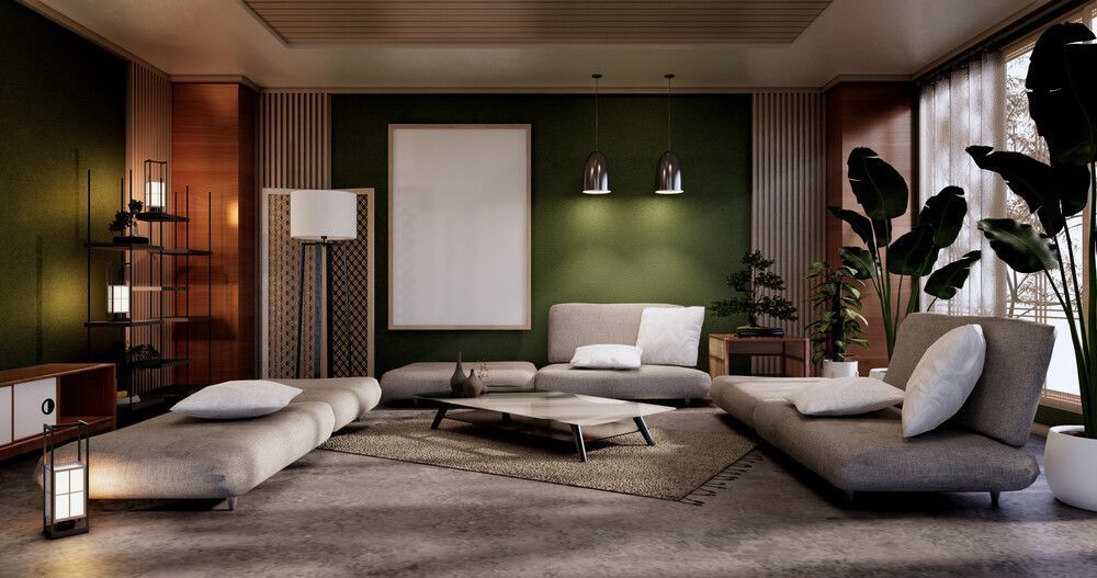 Una sala de estar con paredes verdes, un sofá, una mesa y un cuadro en la pared.