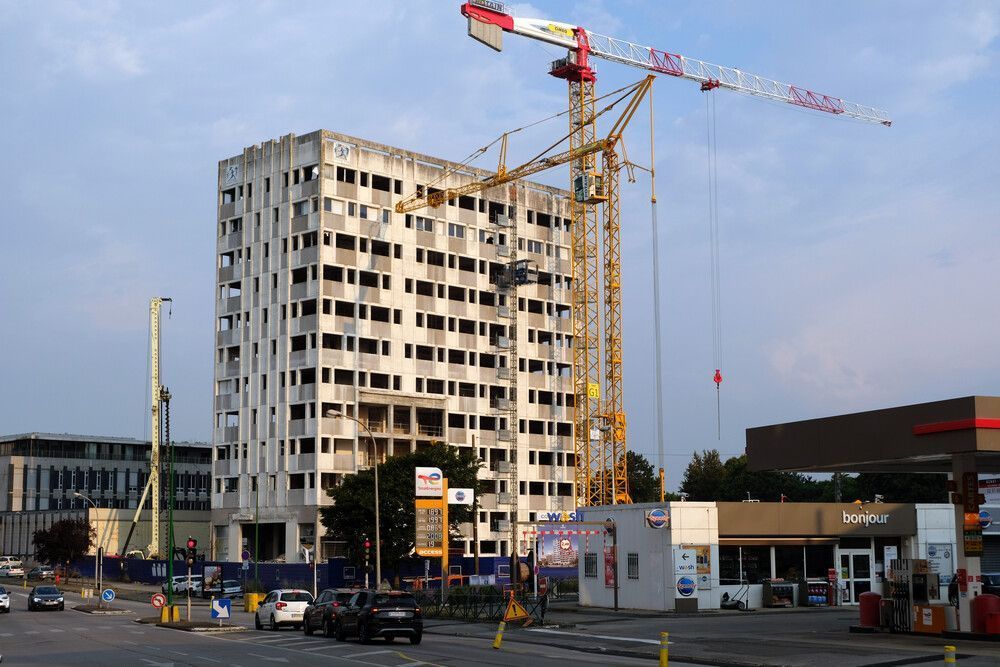 Un gran edificio en construcción con una grúa en primer plano.
