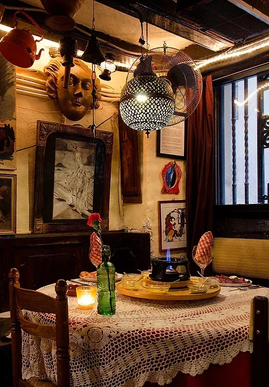 Una habitación con una mesa y sillas y un reloj en la pared.