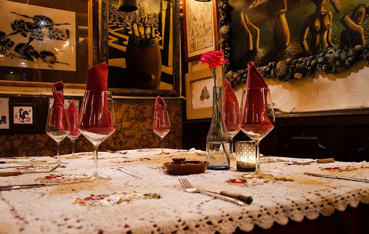 Una mesa con copas de vino y una vela sobre ella en un restaurante.