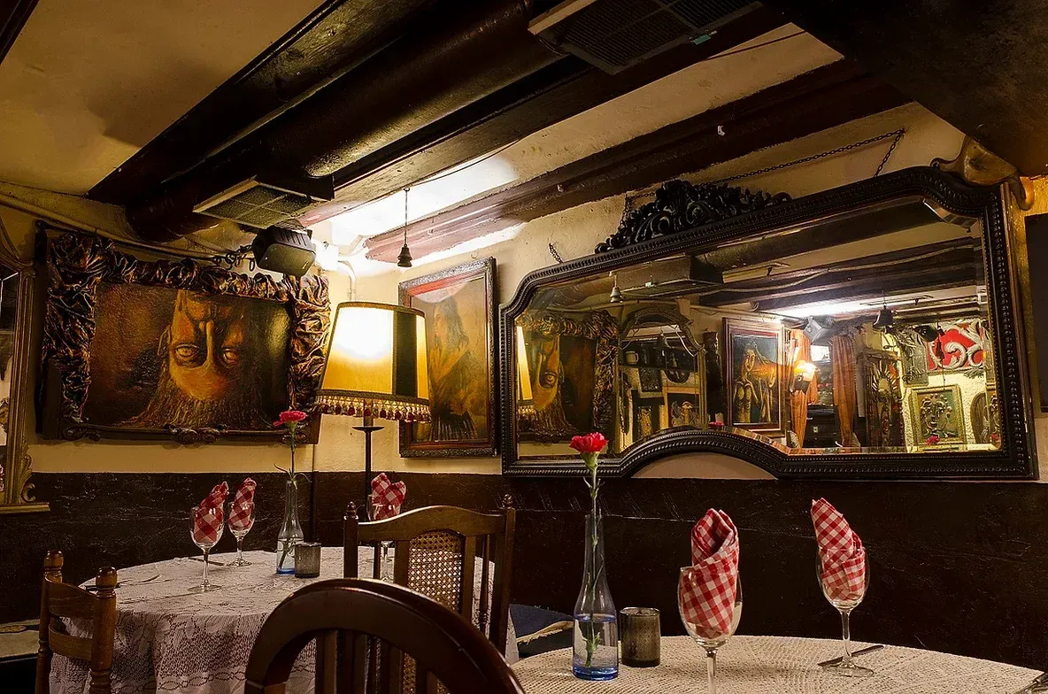 Un restaurante con mesas y sillas y un cuadro en la pared.