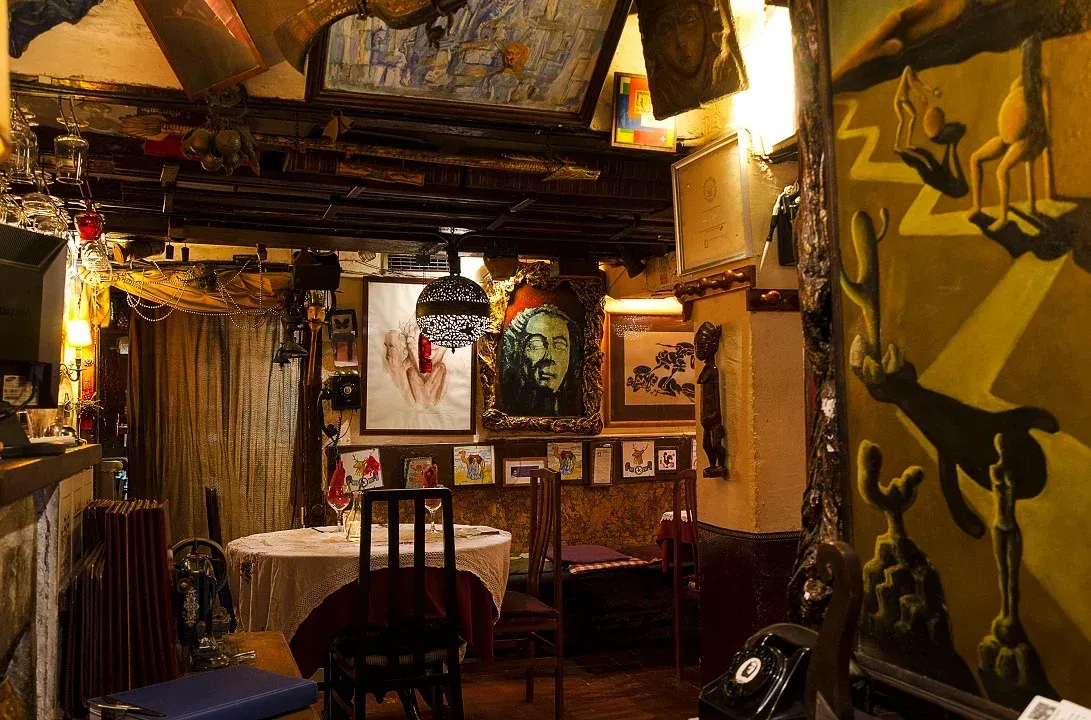 Un restaurante con mesas y sillas y un cuadro en la pared.