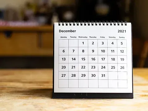 Un calendario para el mes de diciembre está sobre una mesa de madera.