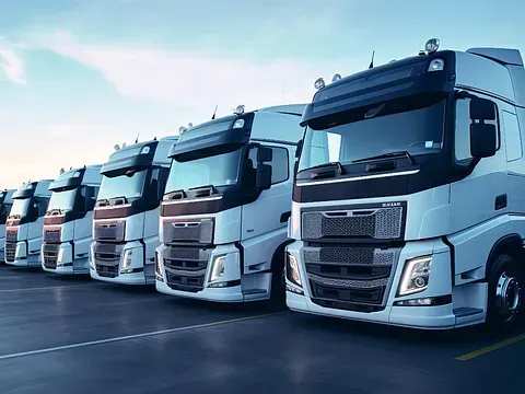 Una fila de camiones semirremolques están estacionados en un estacionamiento.
