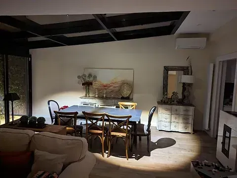 Una sala de estar con una mesa de comedor y sillas y un sofá.