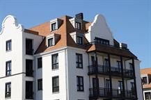 Ein großes weißes Gebäude mit rotem Dach und Balkonen.