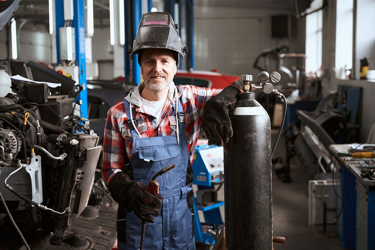 Garagiste avec une bouteille de gaz pour souder