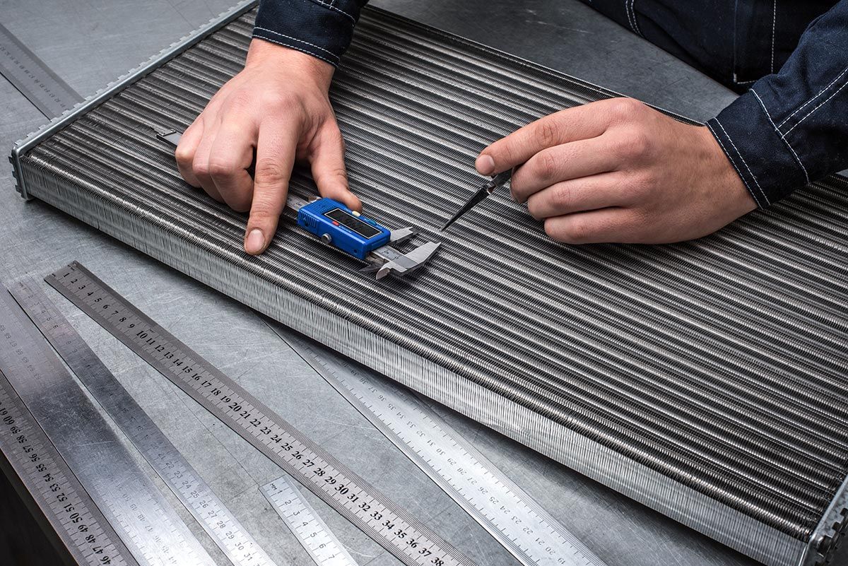 Homme qui prend les mesures sur un radiateur de voiture