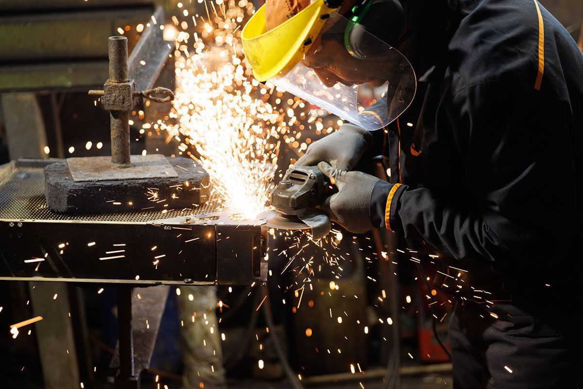 Ouvrier qui passe la disqueuse sur un radiateur de voiture