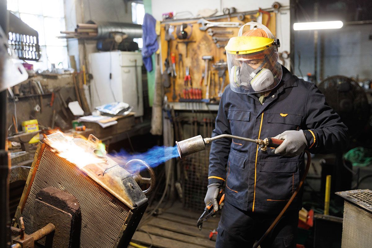 Radiateuriste qui applique un traitement thermique sur le radiateur d'une voiture
