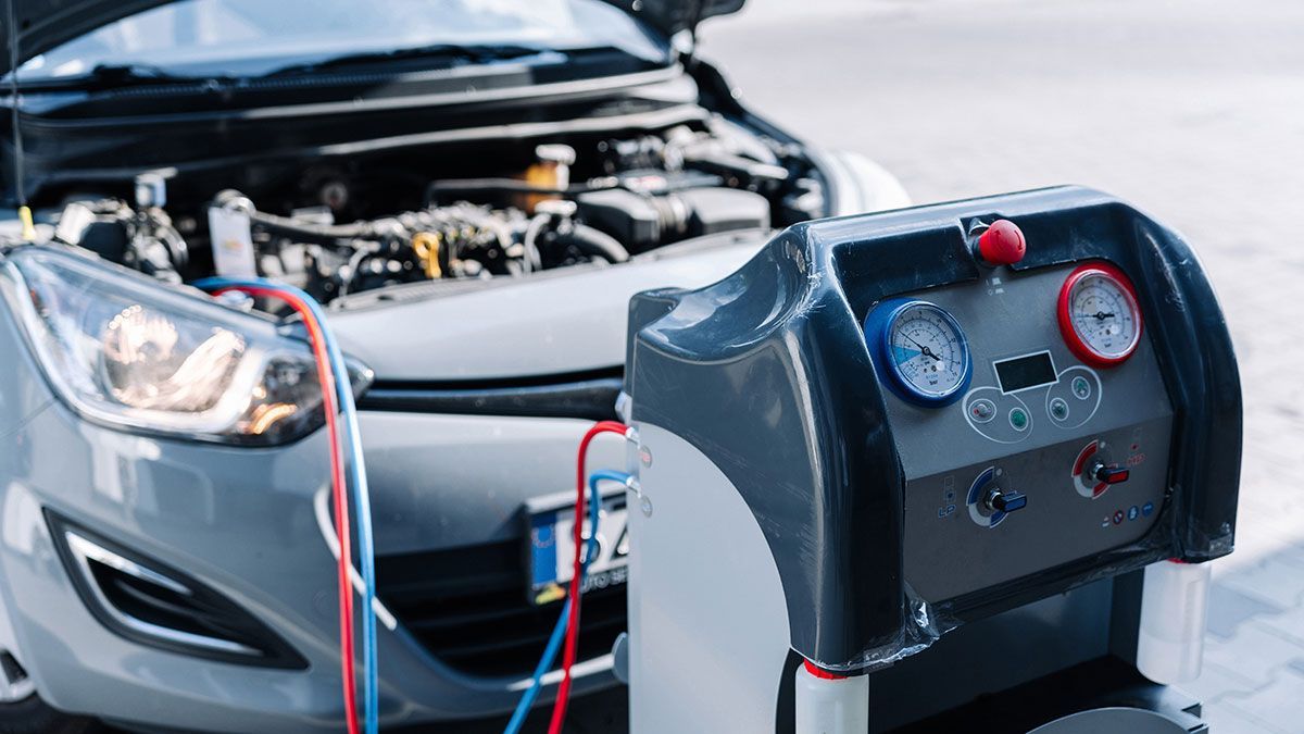 Voiture branchée à un système pour remettre du gaz dans la climatisation