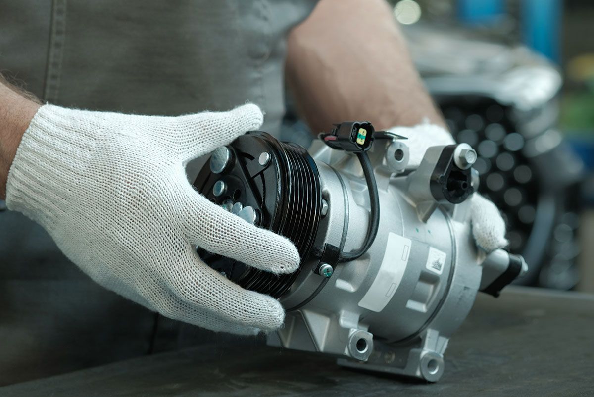 Garagiste qui tient un compresseur de voiture