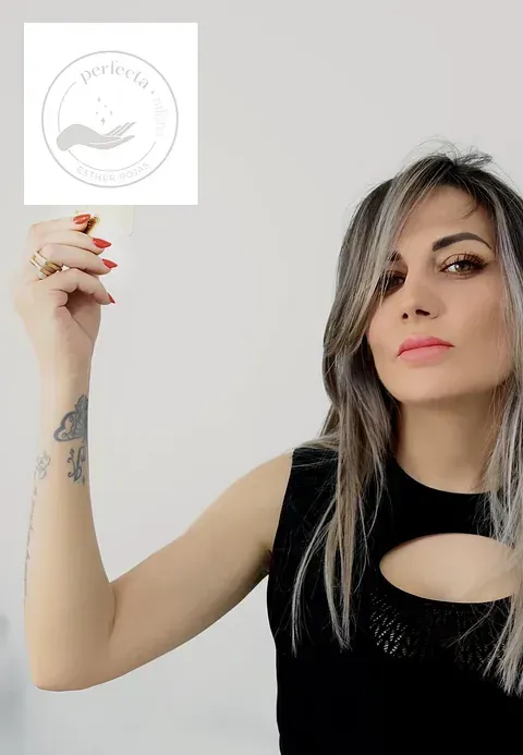 Una mujer con un tatuaje en la muñeca sostiene un trozo de papel.