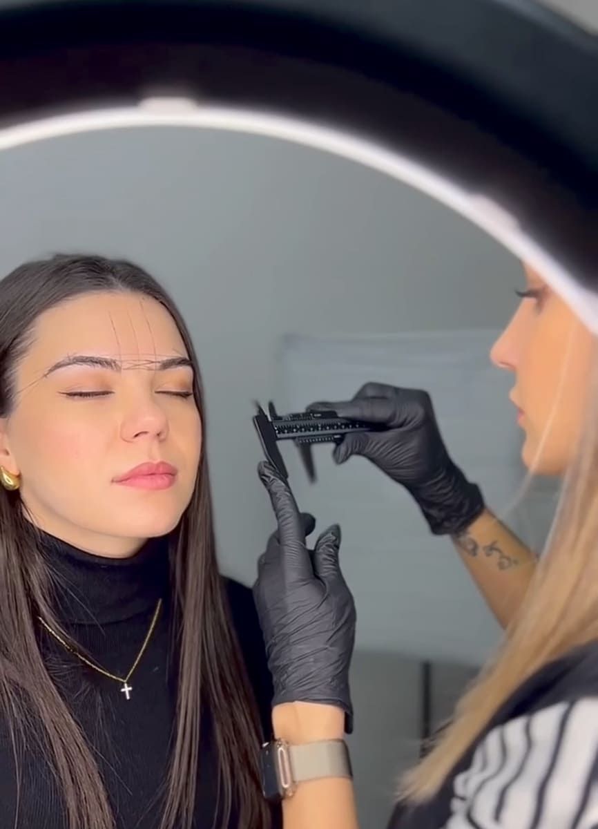 Sillón dental en una clínica moderna con pared acentuada en negro reflectante, iluminación brillante y gabinetes blancos.