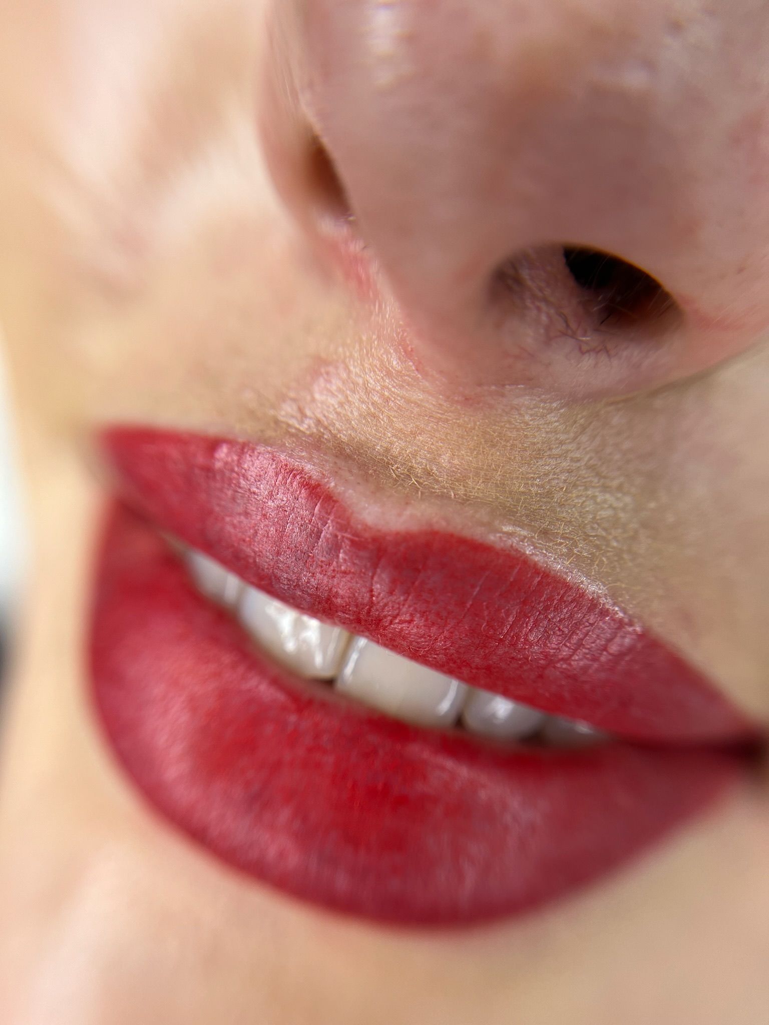 Un primer plano de los labios de una mujer con lápiz labial rojo.