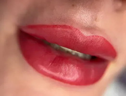 Un primer plano de los labios de una mujer con lápiz labial rojo.
