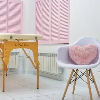 Una silla con una almohada en forma de corazón encima.