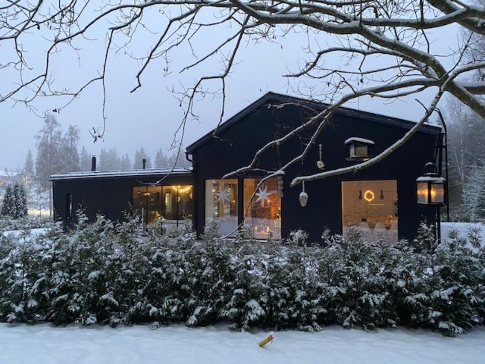 Musta puutalo suurilla ikkunoilla
