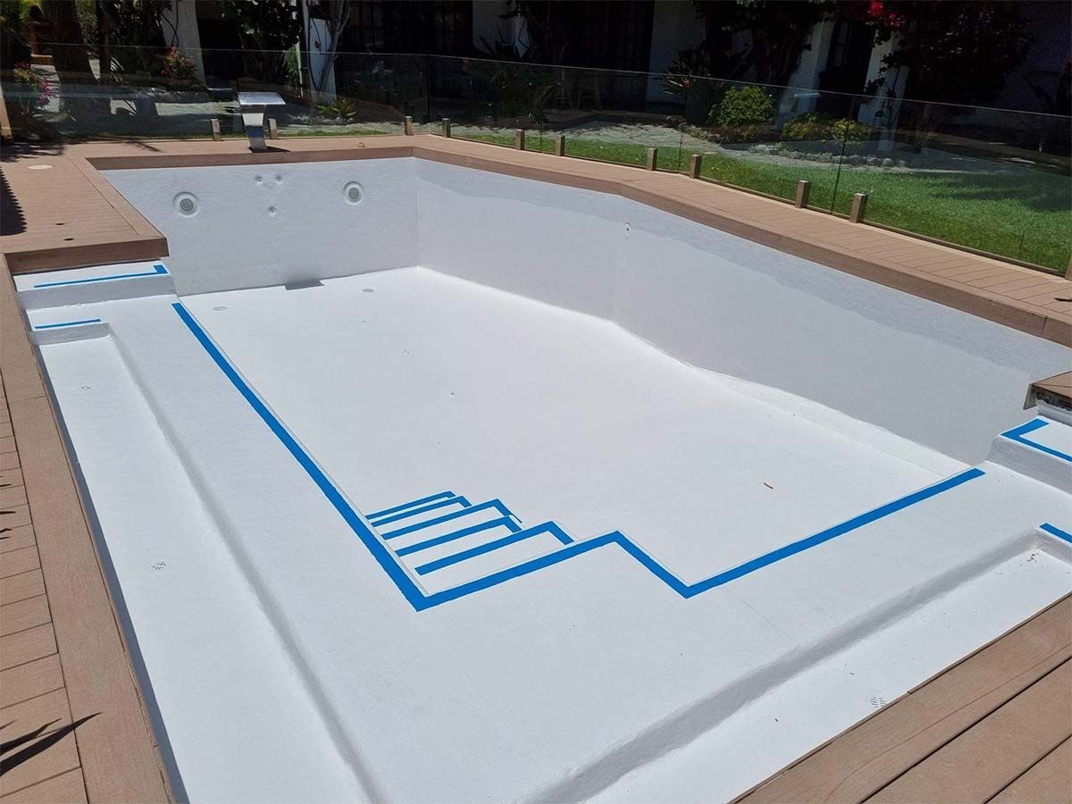 Se está pintando una piscina de blanco con cinta azul.