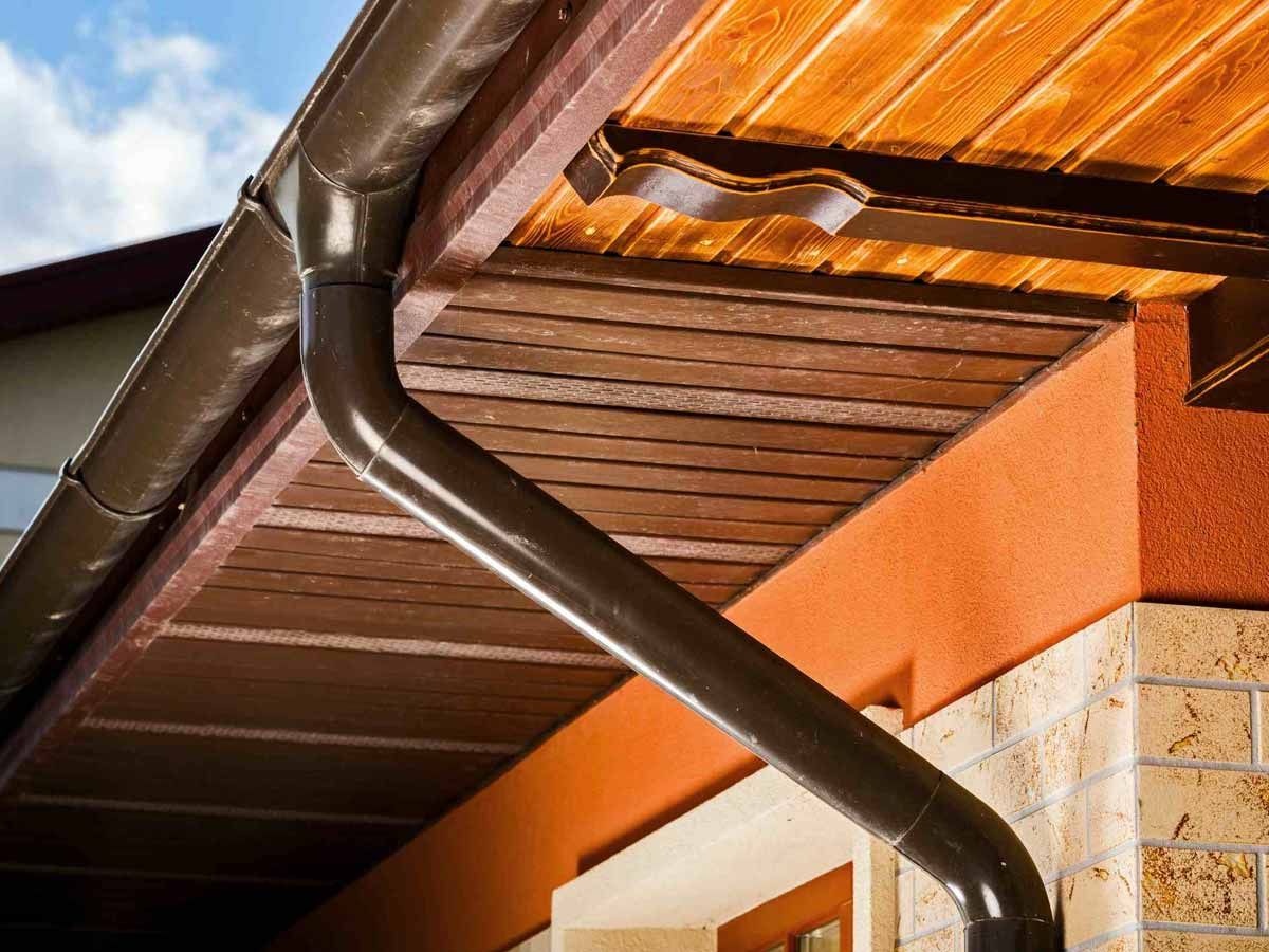 Un primer plano de una canaleta en el costado de una casa.