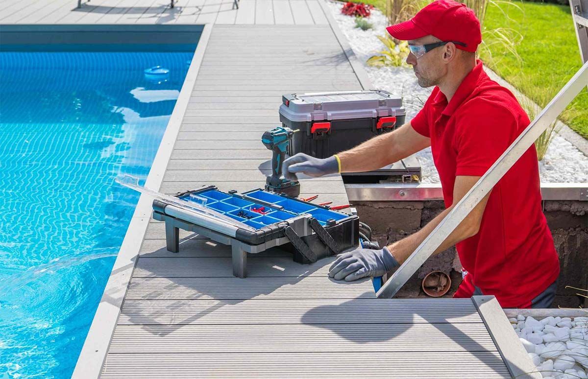 Un hombre con una camisa roja está trabajando en una piscina.