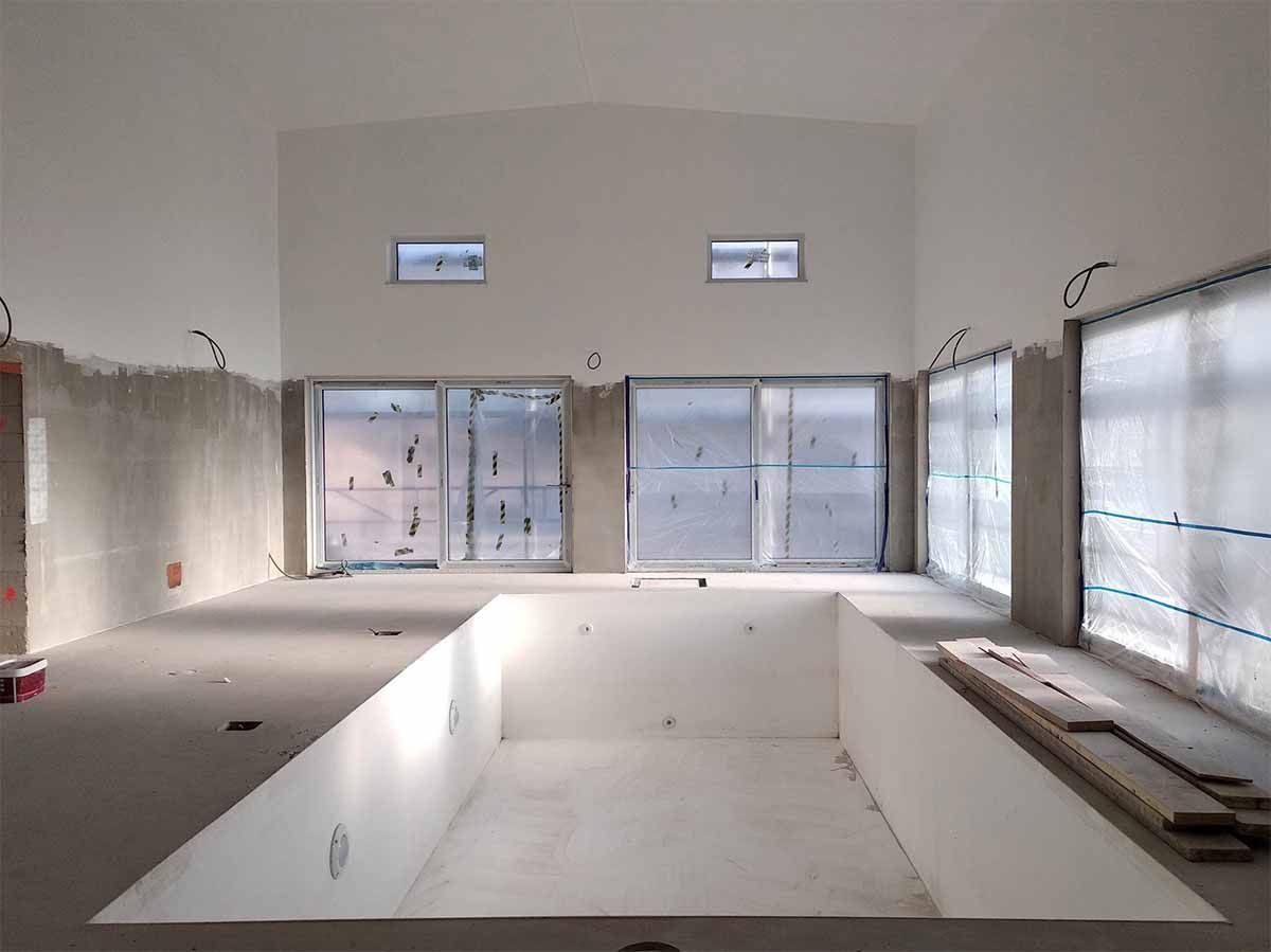 Una habitación vacía con una gran piscina en el medio.