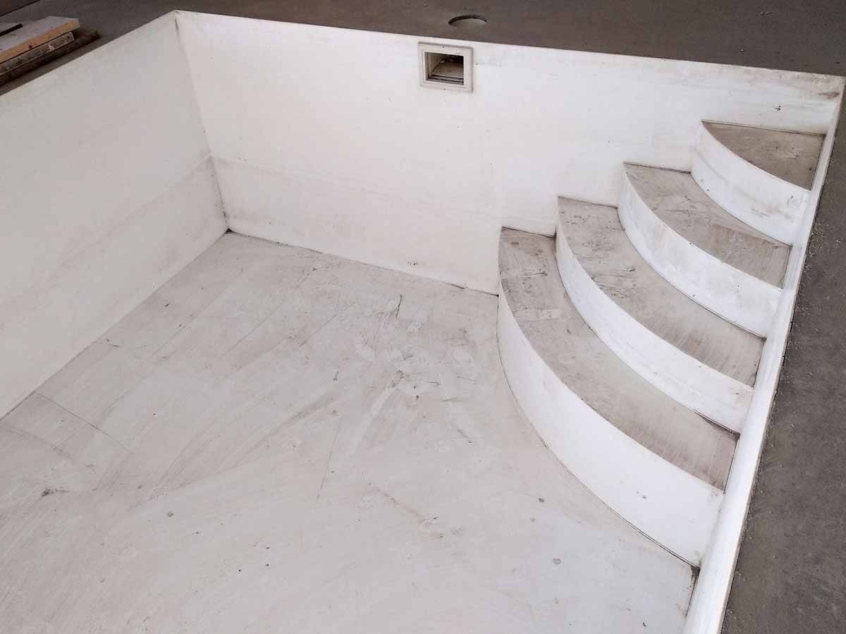 Una piscina blanca con escaleras que conducen a ella.