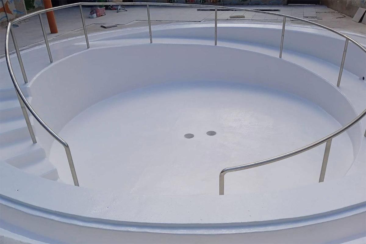 Una piscina circular con escaleras y barandilla de acero inoxidable.