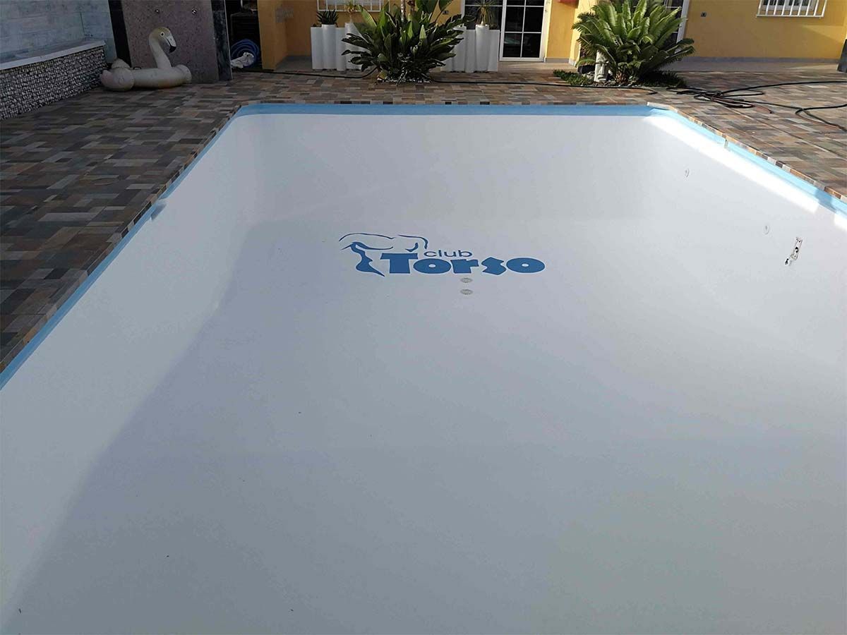 Una gran piscina blanca con un logotipo azul en el suelo.