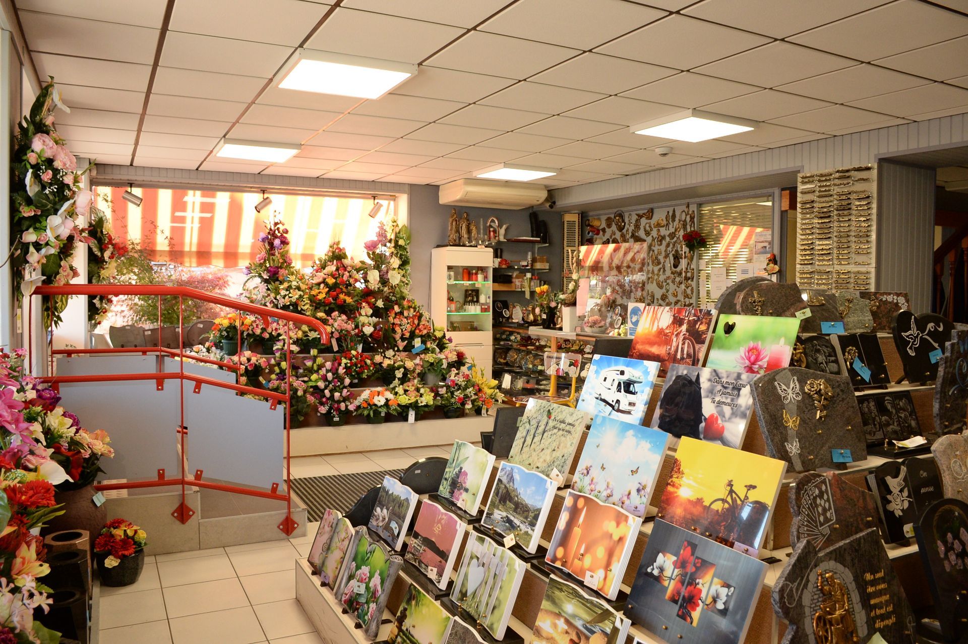 À l'intérieur d'un magasin de fleurs, des étalages de fleurs colorées et des plaques commémoratives, un éclairage lumineux.