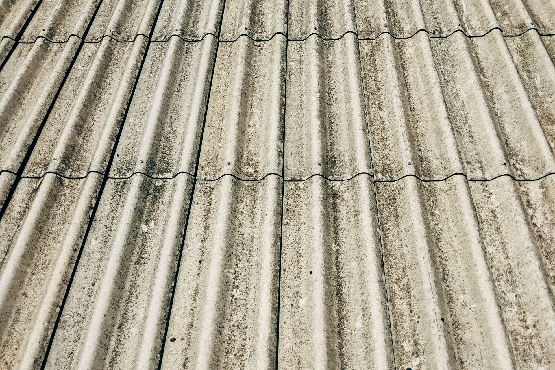 Pièce partiellement démolie avec des murs apparents, des gravats au sol et des fenêtres laissant entrer la lumière du jour.