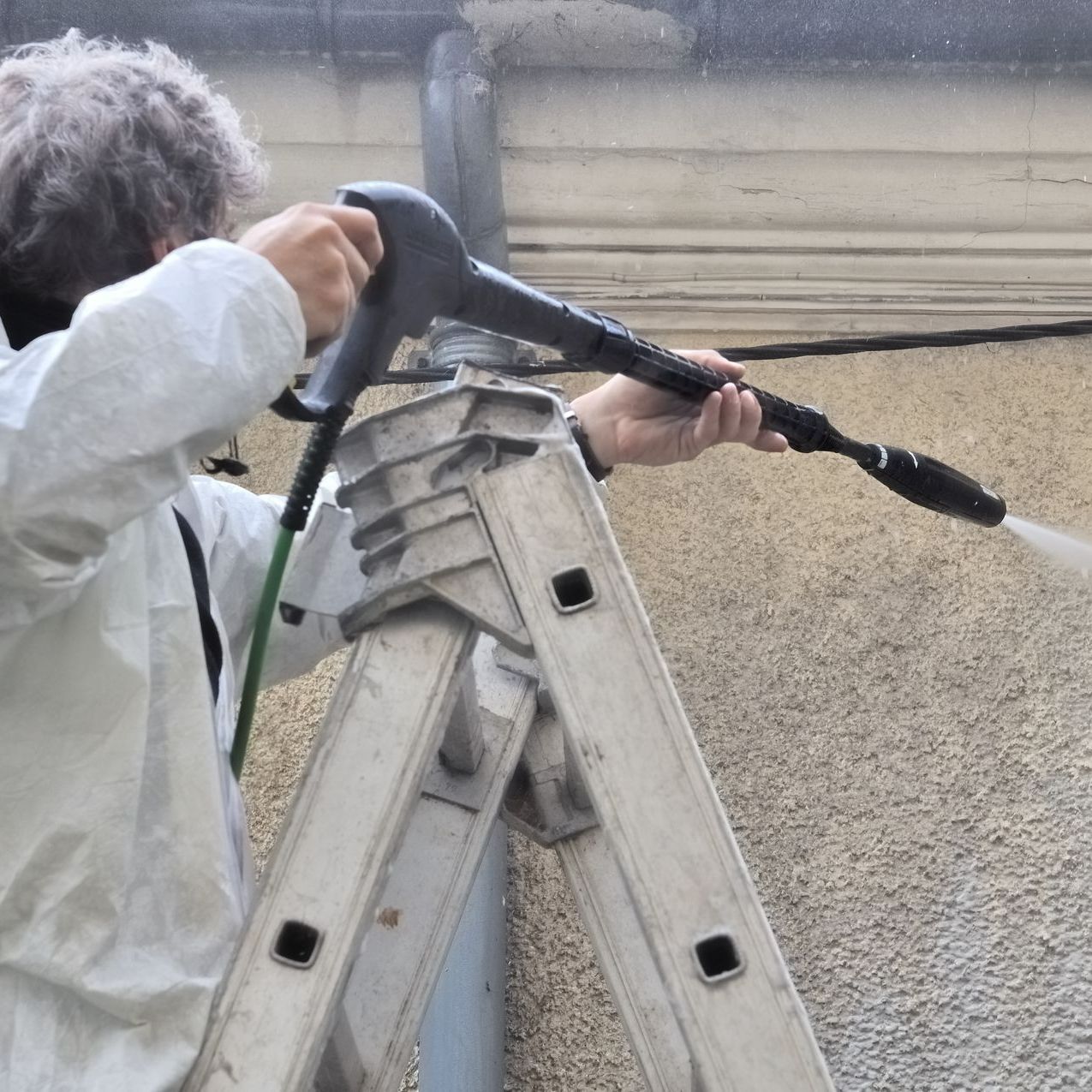 Un artisan nettoie une façade