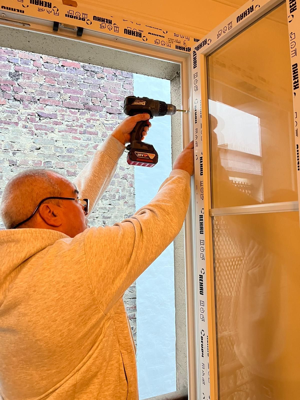 Un homme visse une fenêtre