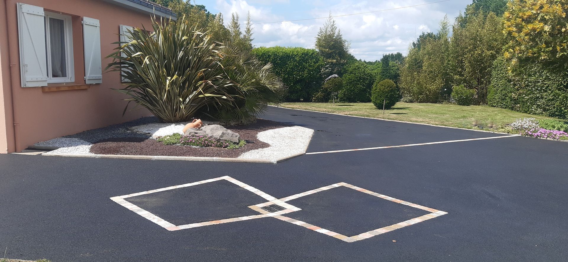 Une allée pavée bordée d'une maison et de verdure. Au premier plan, deux losanges imbriqués.