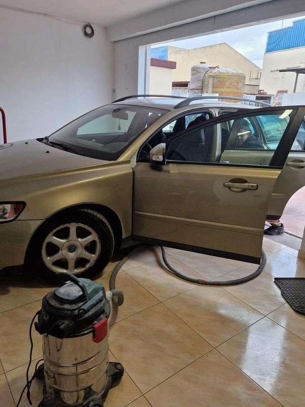 Un sedán dorado con la puerta abierta 