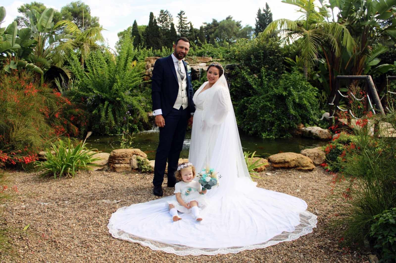Una pareja de recién casados y un niño pequeño posan para una foto de boda.