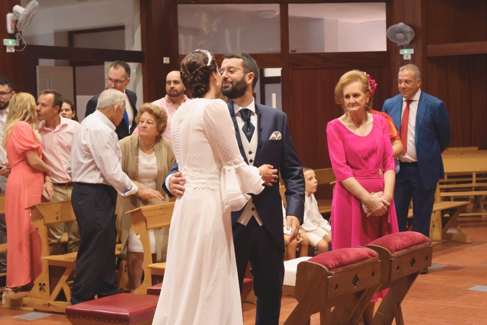 Los novios se abrazan y se besan en el altar tras la ceremonia. 