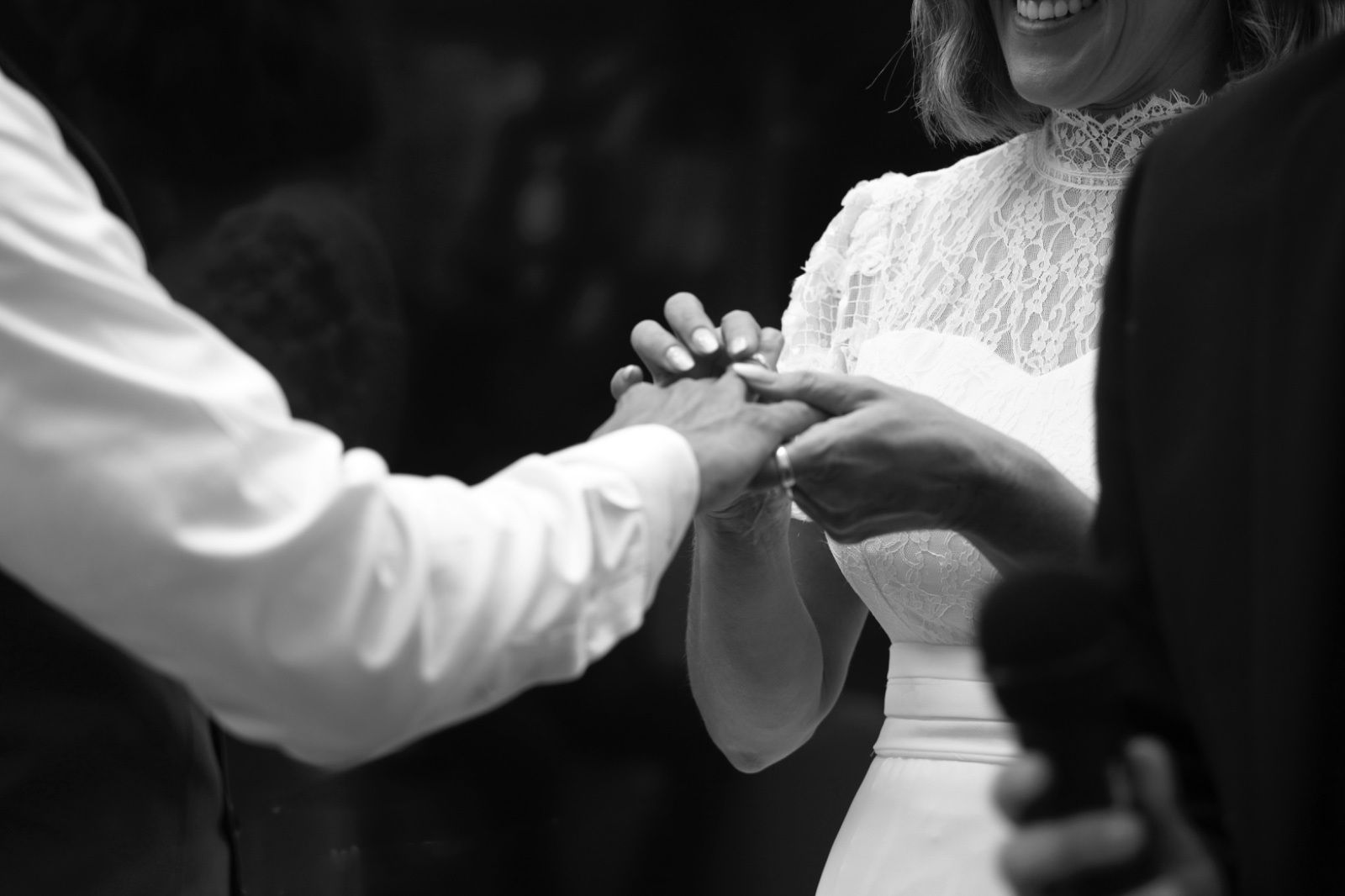 Novia colocando un anillo en el dedo del novio durante una ceremonia nupcial. 