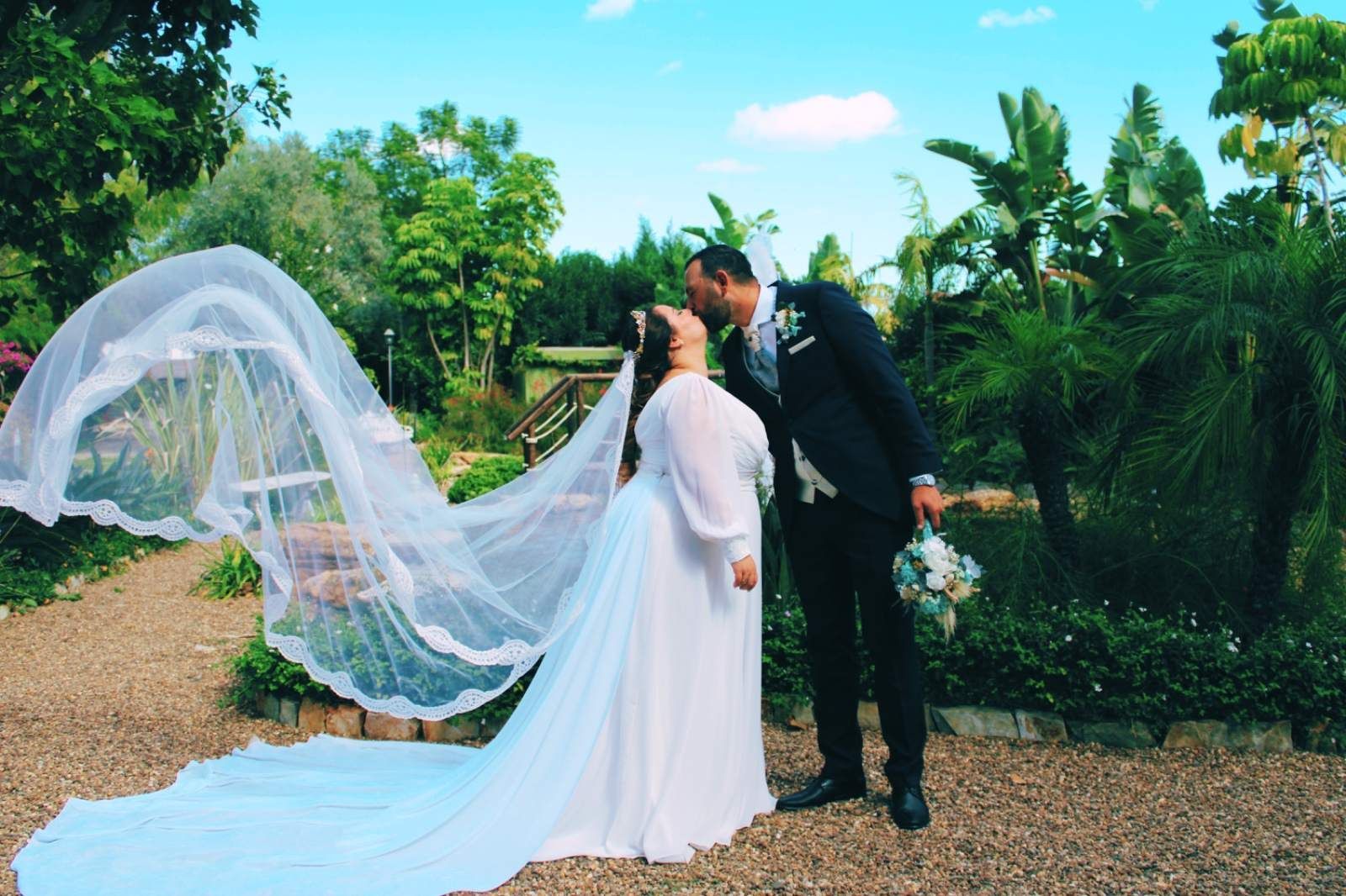 Los recién casados se besan en un jardín.