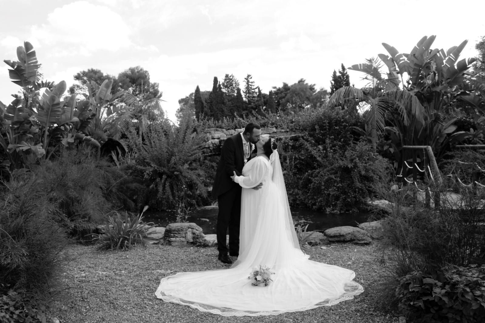 Fotografía en blanco y negro de una pareja de recién casados besándose. 