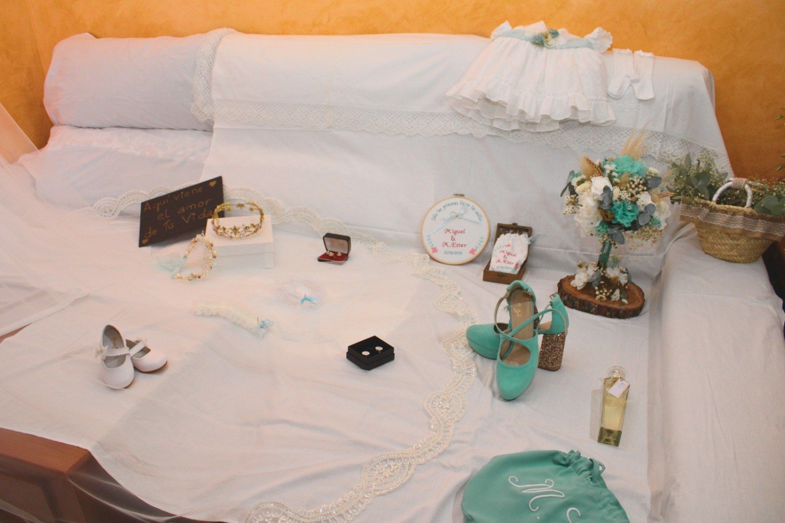 Una exhibición de accesorios de boda: zapatos, joyas, un vestido y un ramo.