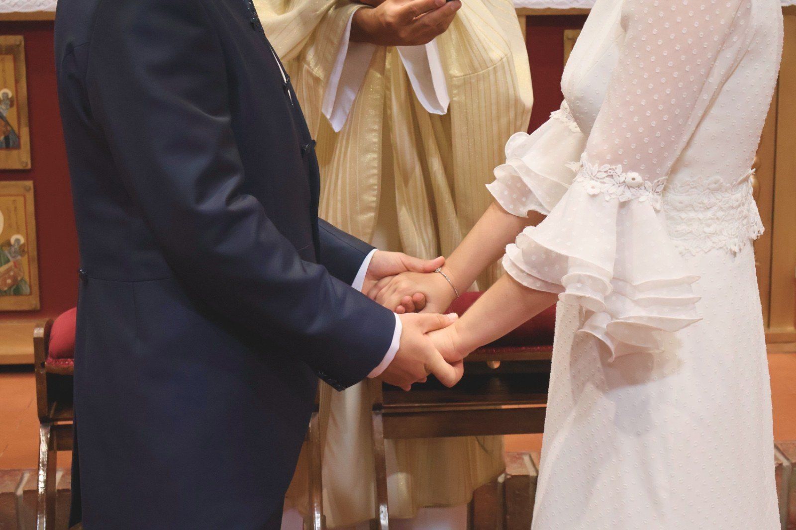 Pareja tomada de la mano durante una ceremonia de boda.
