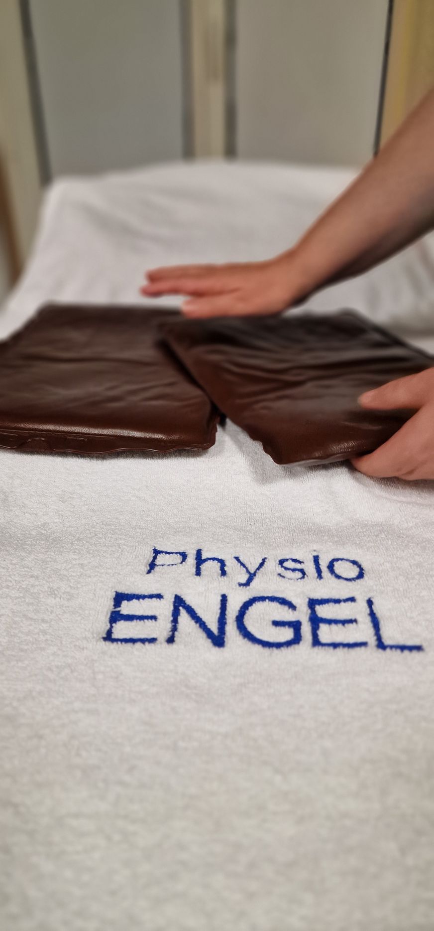 Zwei Personen halten ein kleines gelbes Haus in ihren Händen.