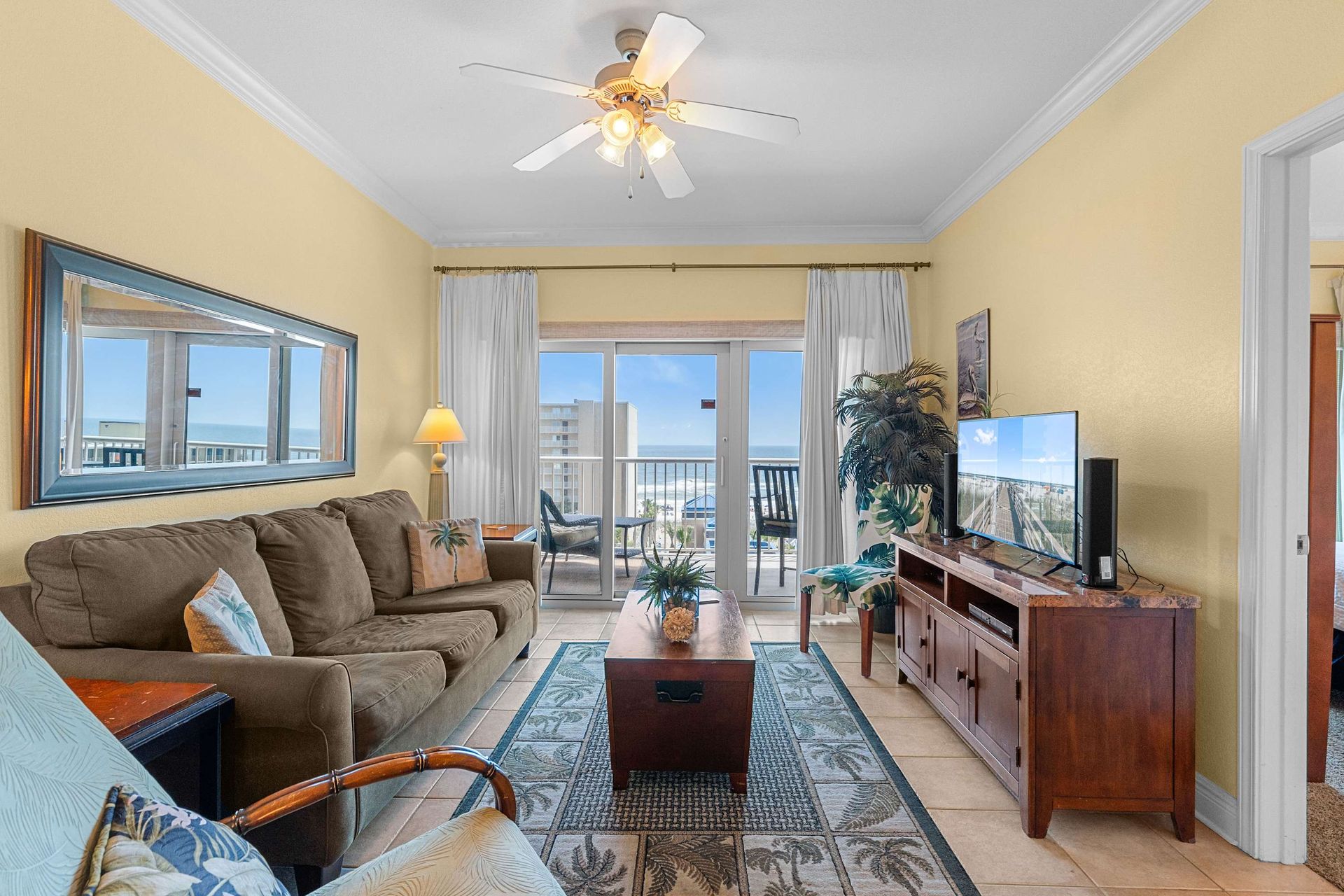 Living room with ocean view, TV and balcony.