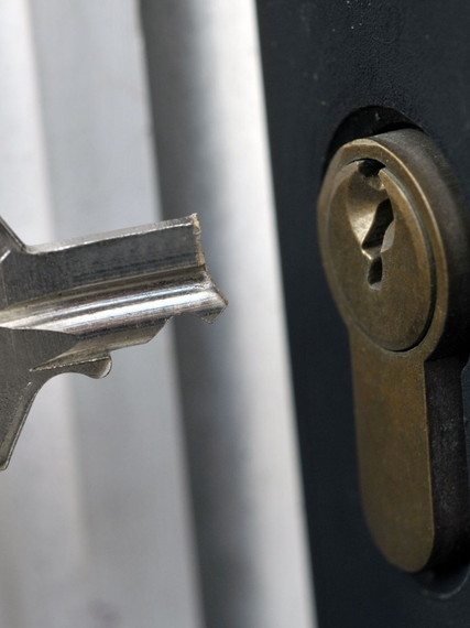 Clé insérée dans une serrure en laiton sur une poignée de porte noire