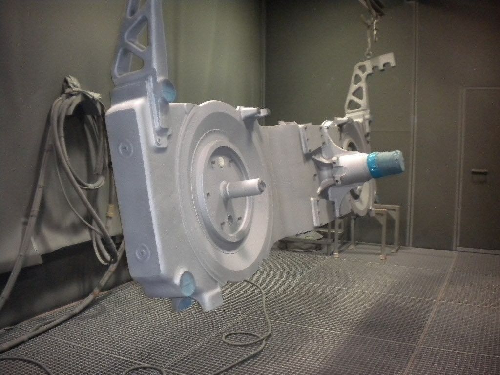 Graue Metallteile in Reihen angeordnet, möglicherweise in einer Fabrikumgebung.