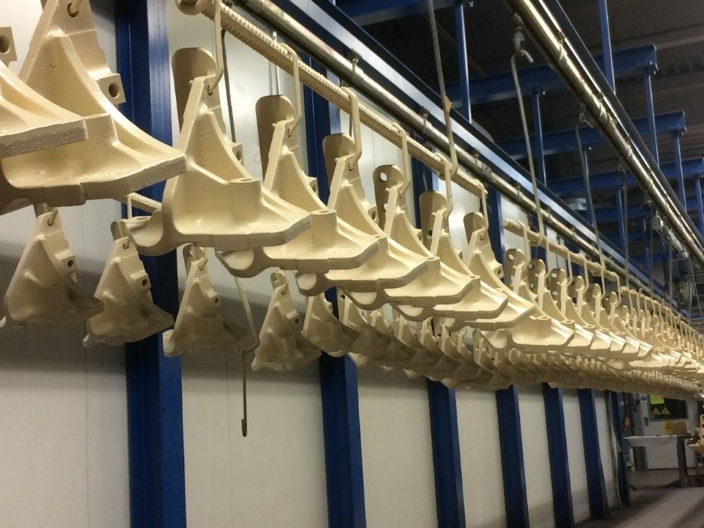 Gelbe Zuführungen hängen an einem Förderband in einer Fabrik.